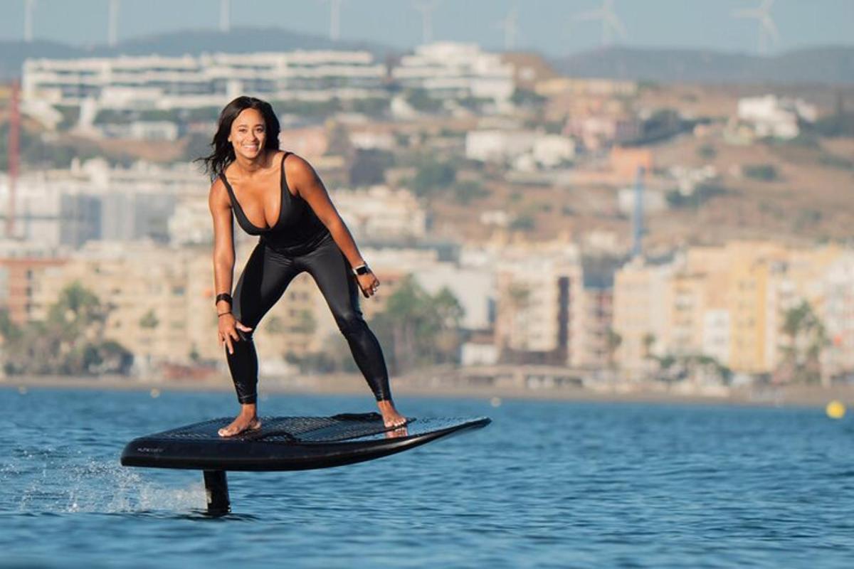 una donna in piedi su una tavola da surf in acqua