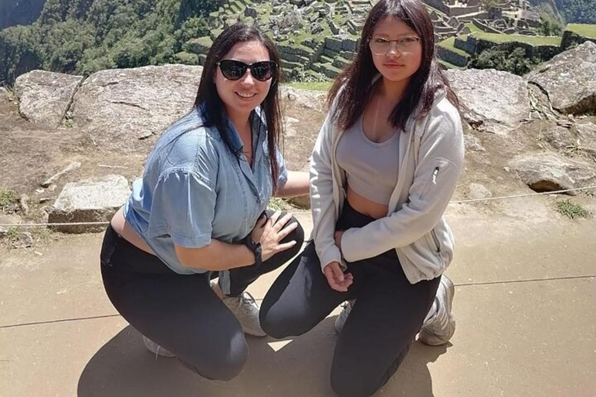 Dos mujeres están sentadas en una cornisa de roca