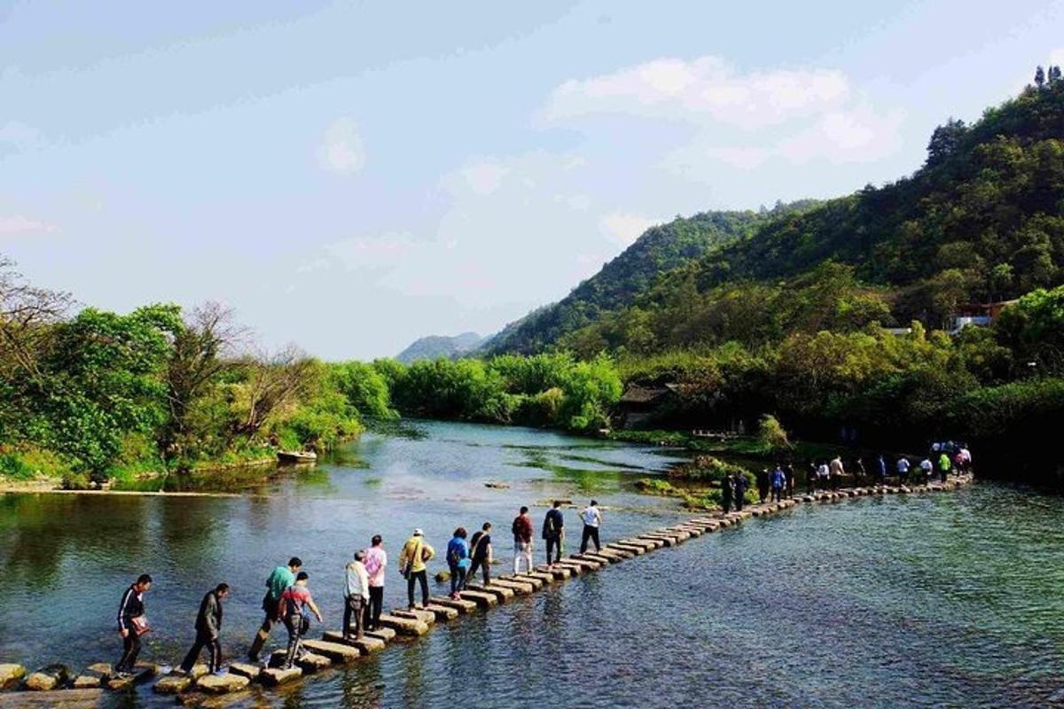 a group of people crossing a bridge over a river