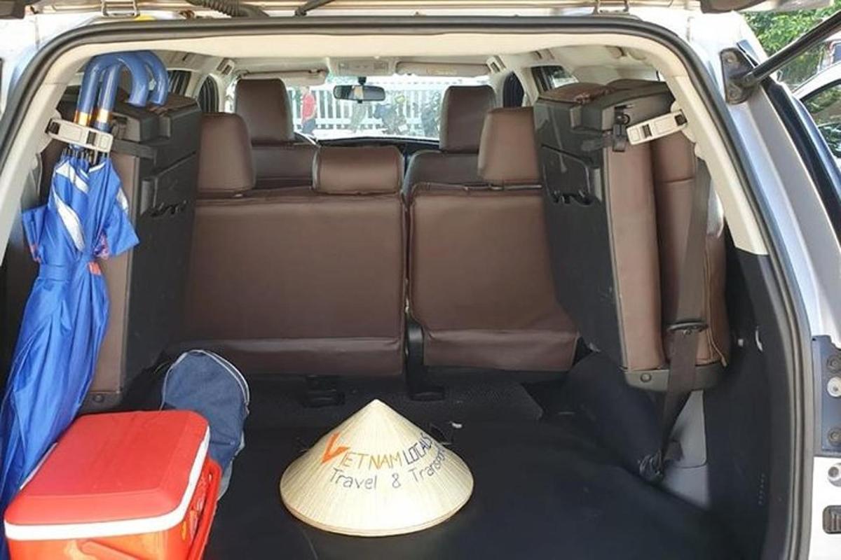 tempat duduk belakang terbuka sebuah van dengan topi dan papan luncur