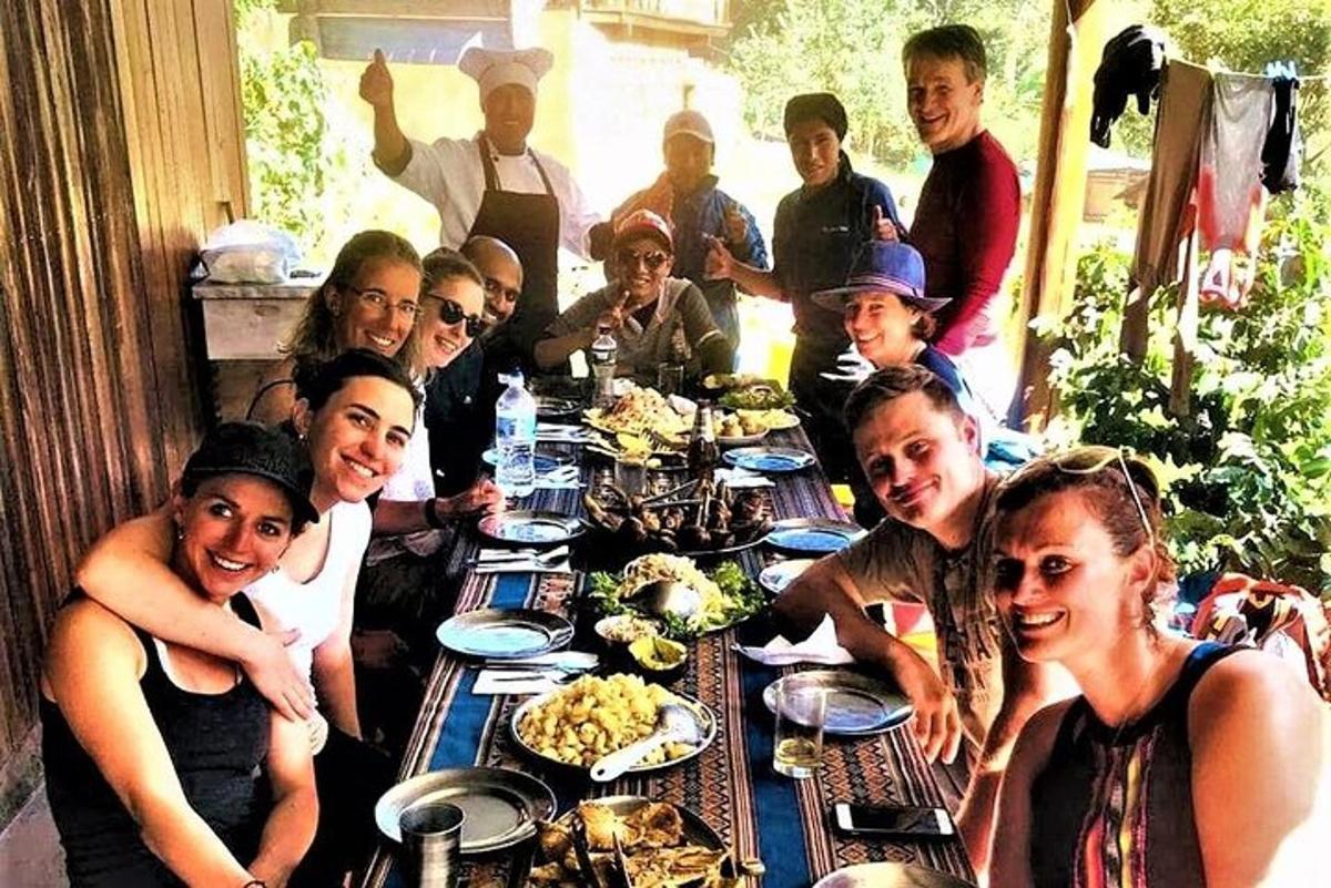 Un grupo de personas sentadas alrededor de una mesa con comida.