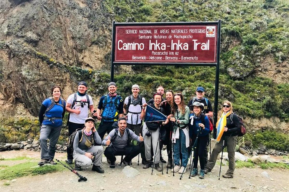 un gruppo di persone in posa per una foto davanti a un cartello