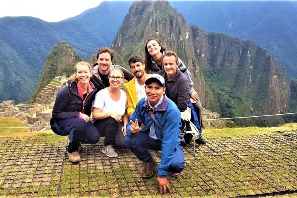 un grup de oameni care pozează pentru o fotografie în vârful unui munte
