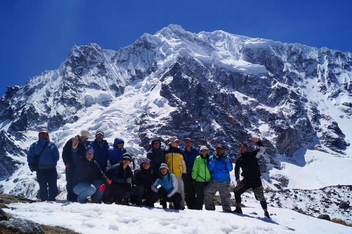 en gruppe mennesker som står på toppen av et fjell
