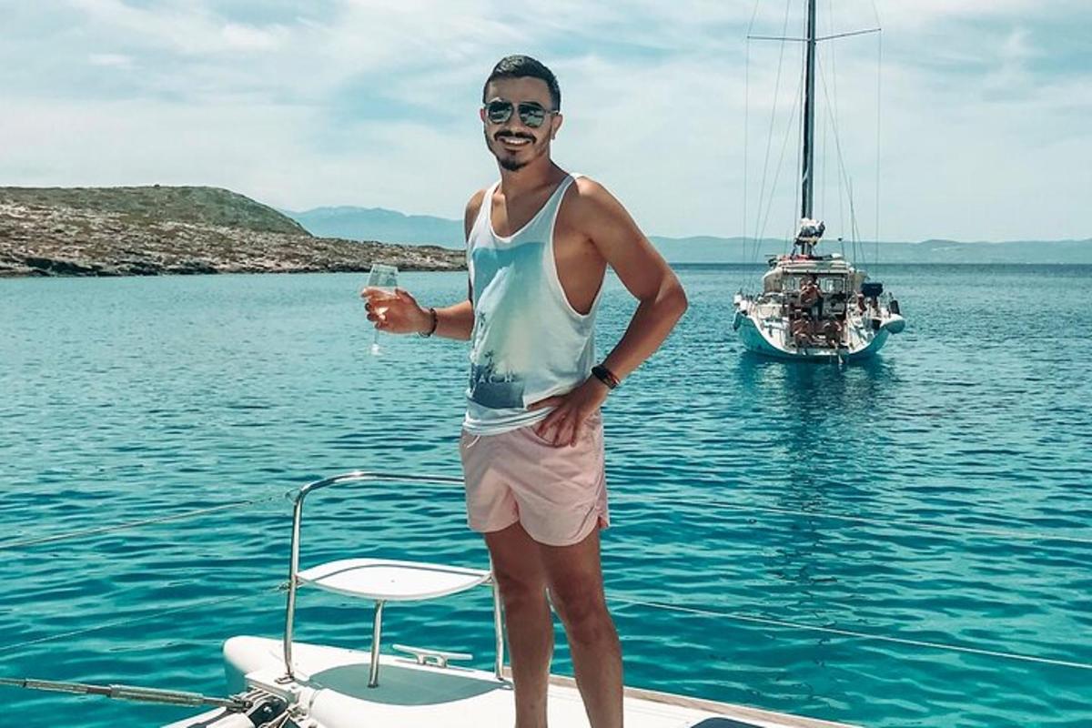 un uomo in piedi sul retro di una barca in acqua