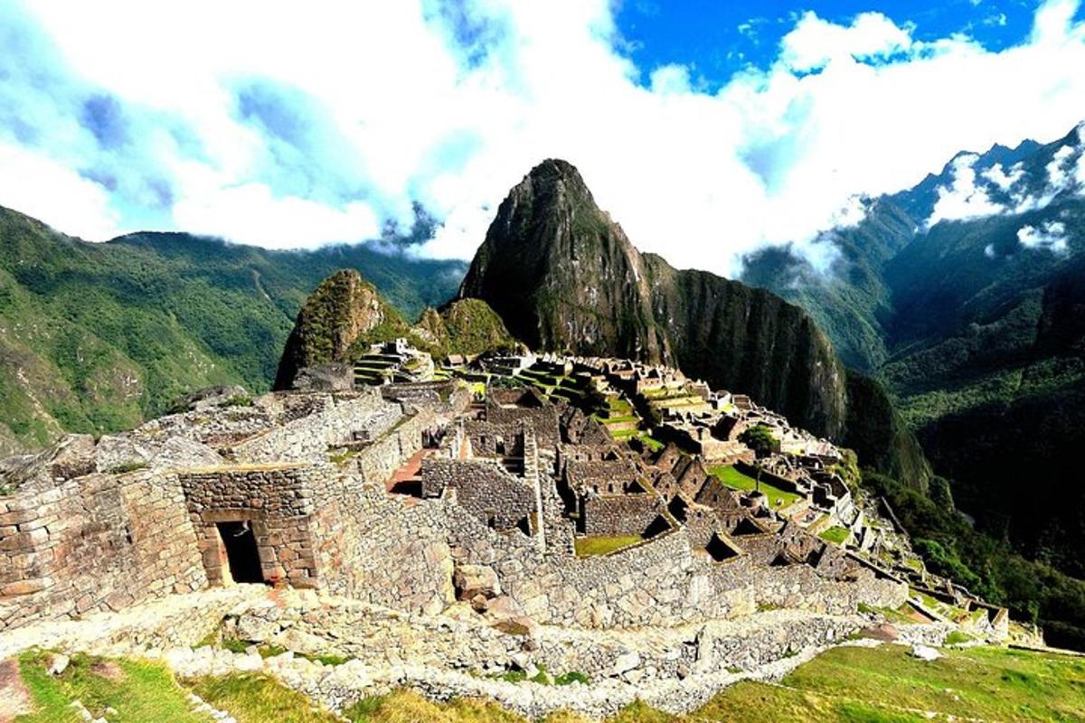 an ancient building on a mountain with mountains in the background