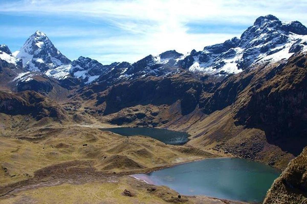 uma cadeia de montanhas com um lago em primeiro plano