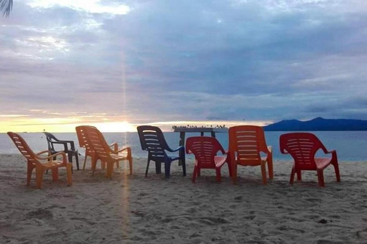 um grupo de cadeiras sentadas ao redor de uma mesa na praia