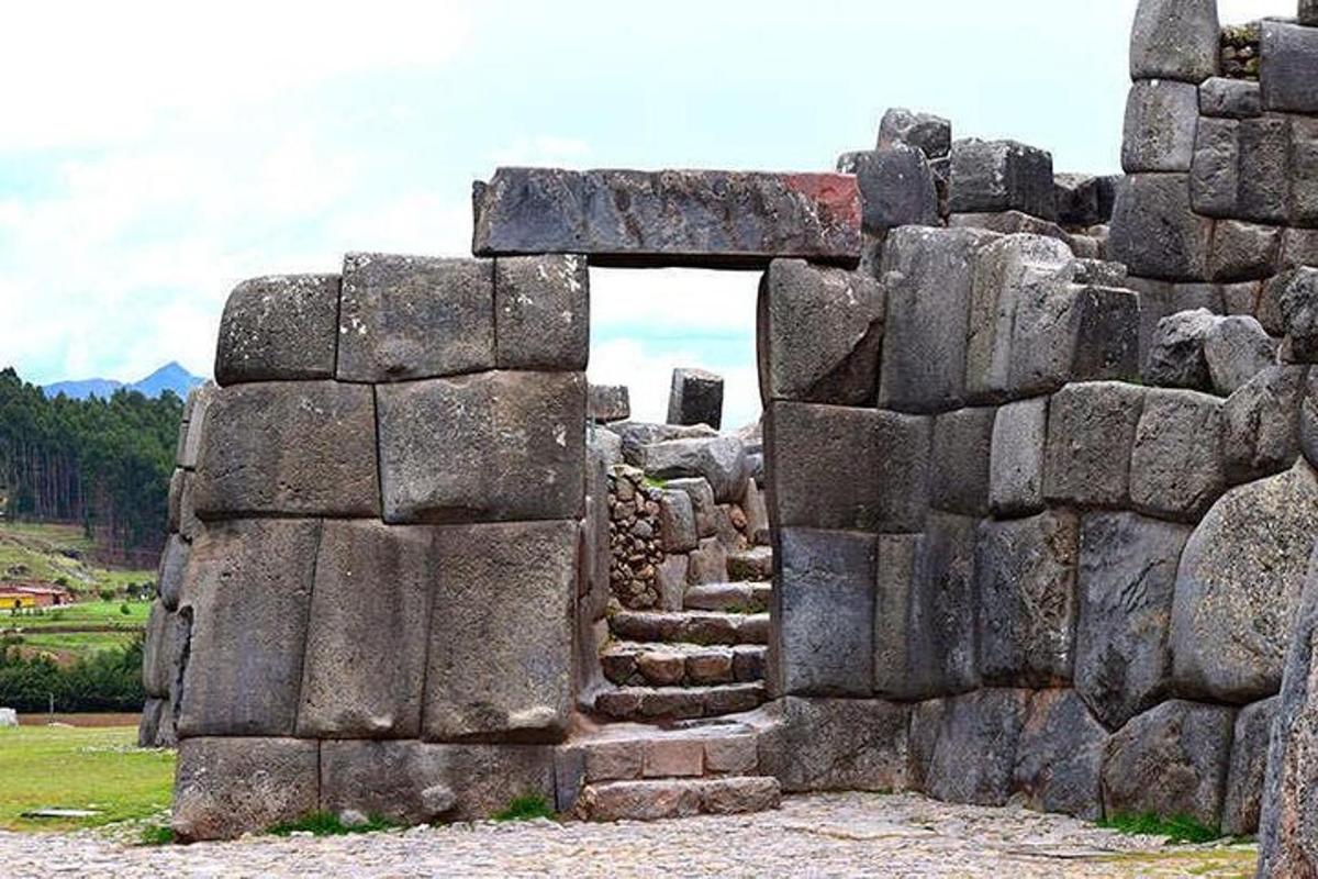 a stone building with a doorway in a field