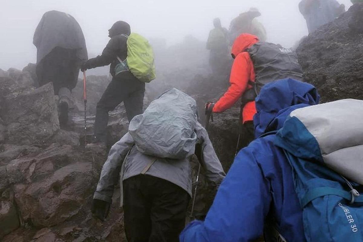 un gruppo di persone su una montagna nella nebbia