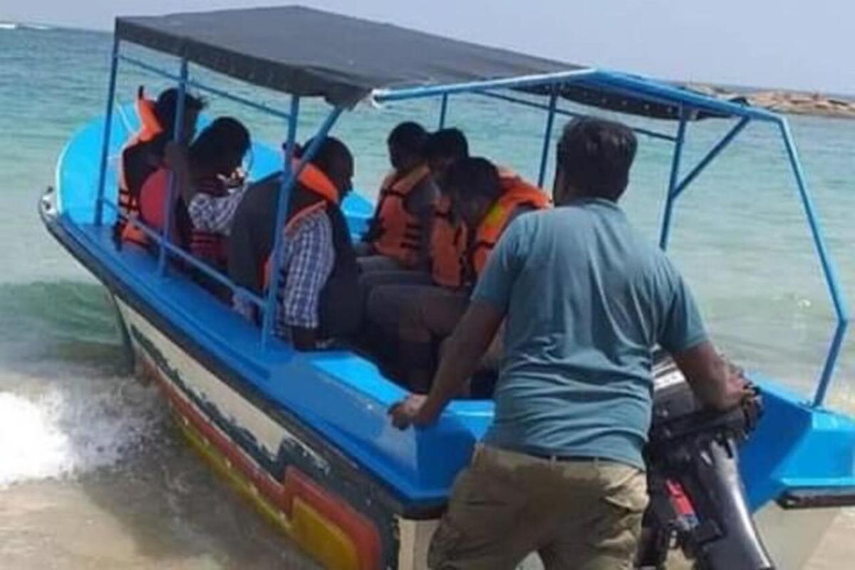 a group of people in a blue boat on the beach