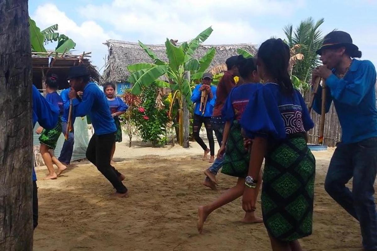 un grupo de personas bailando en la playa