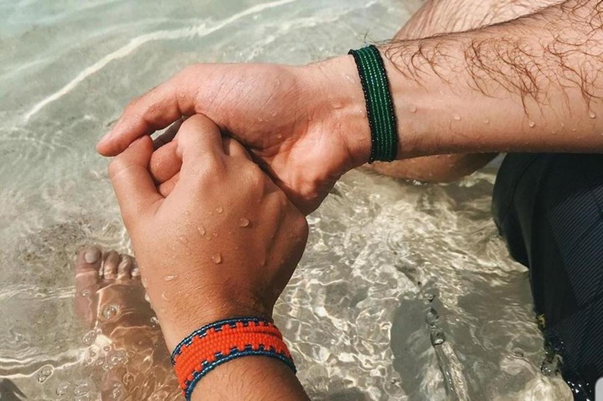 a person holding the hand of a person in the water