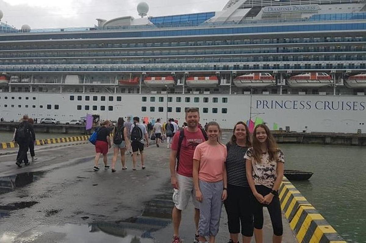 Un grupo de personas de pie frente a un crucero.