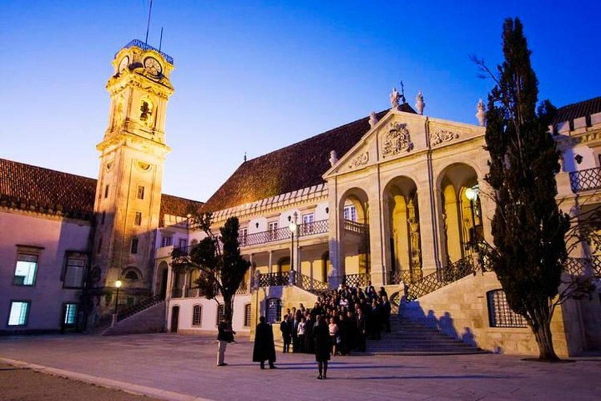 μια ομάδα ανθρώπων που στέκονται μπροστά από ένα κτίριο με έναν πύργο ρολογιού