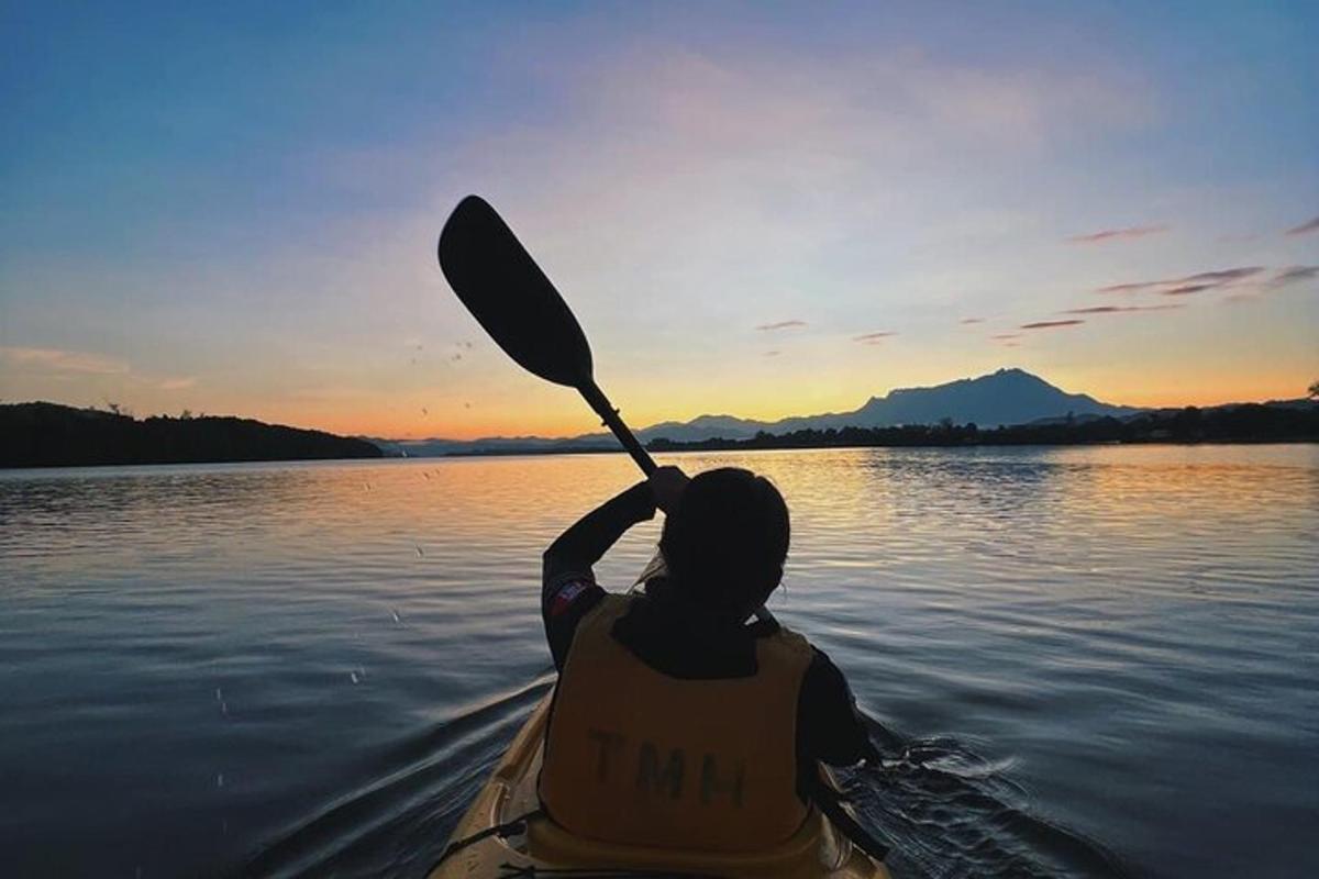 seseorang dalam kayak di atas air dengan dayung