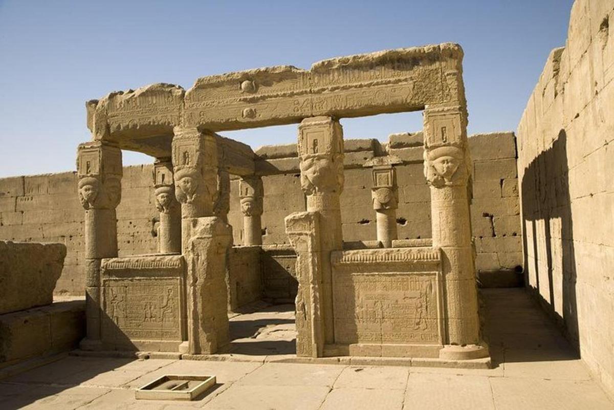 an ancient building with pillars and a wall