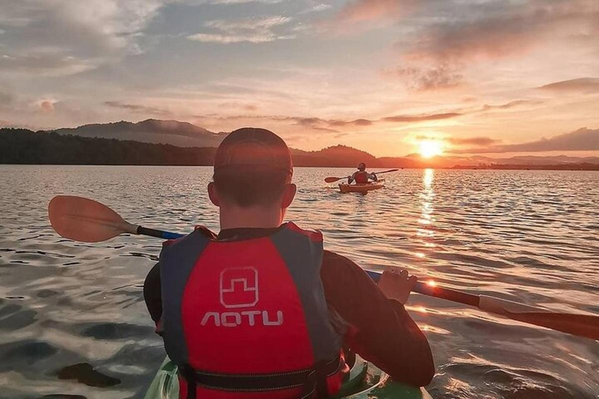 dua orang dalam bot di tasik pada waktu matahari terbenam