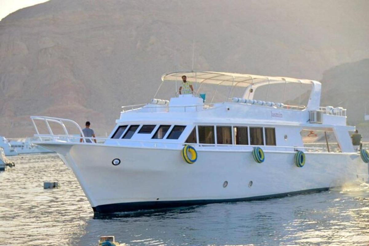 Un barco blanco en el agua con dos personas en él.