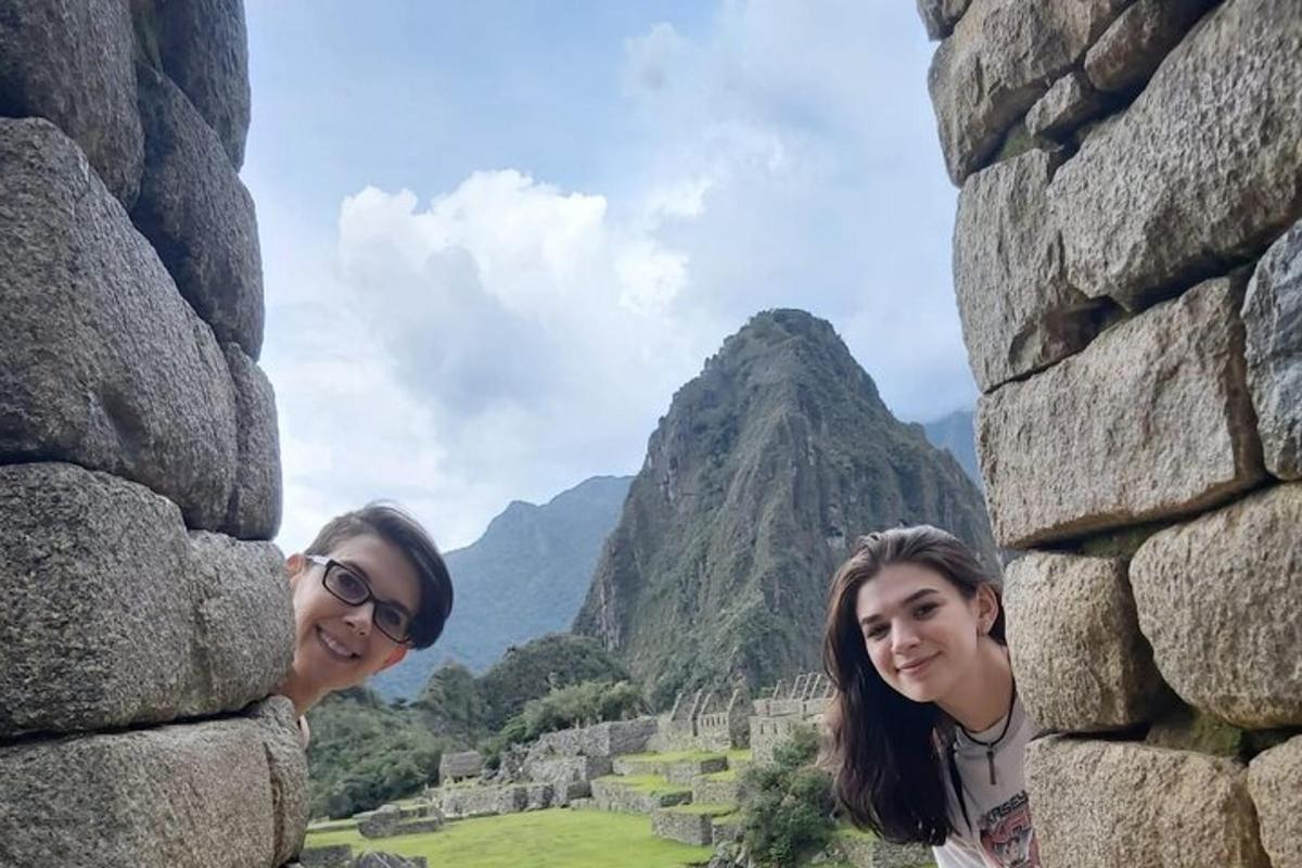 due donne in piedi accanto a una parete rocciosa con una montagna