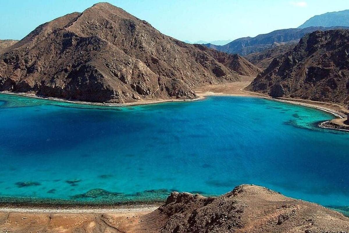un grande lago blu in mezzo a una montagna