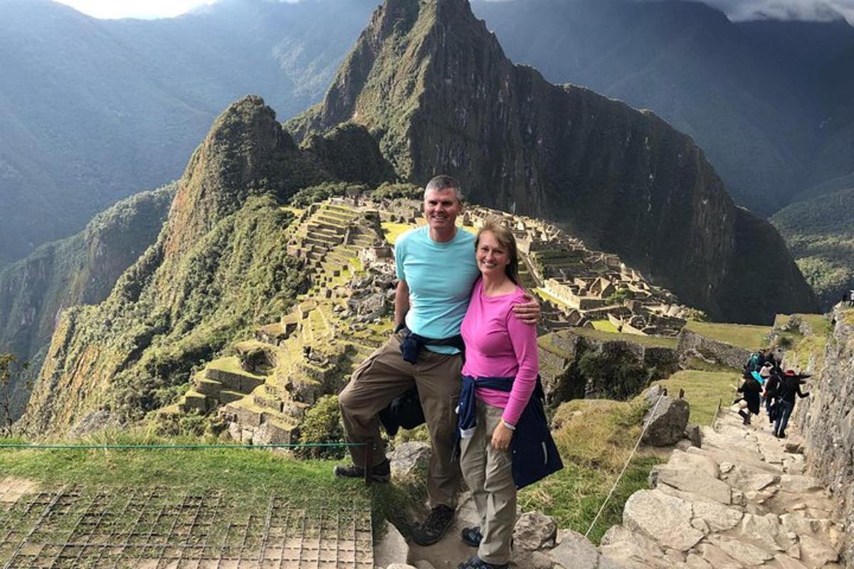 un uomo e una donna in piedi sulla cima di una montagna
