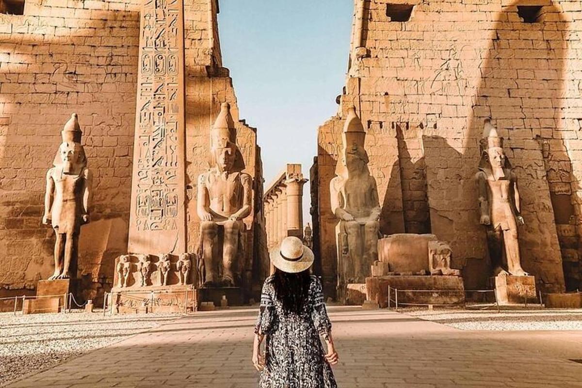 une femme avec un chapeau debout devant un bâtiment