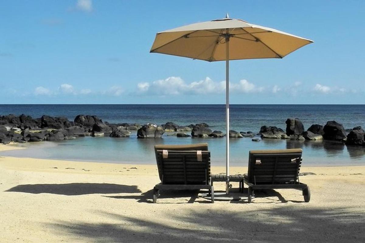 Dos sillas y una sombrilla en una playa