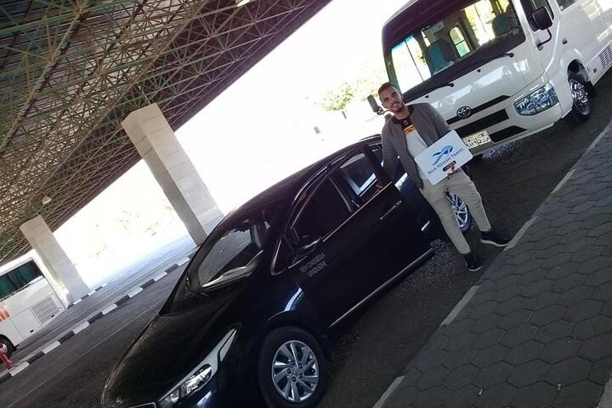 un uomo è in piedi accanto a un'auto nera