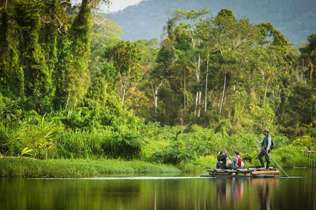 một người đàn ông đang đứng trên một chiếc bè trong nước