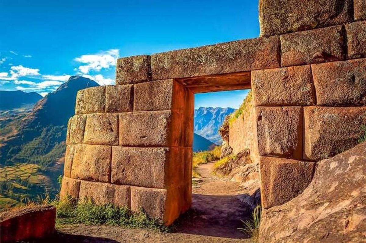 uma porta em uma parede de pedra com vista para as montanhas