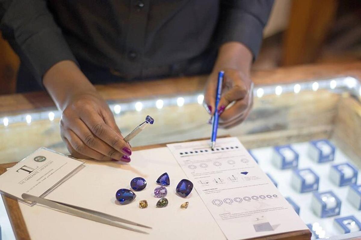 a person is writing on a table with gemstones