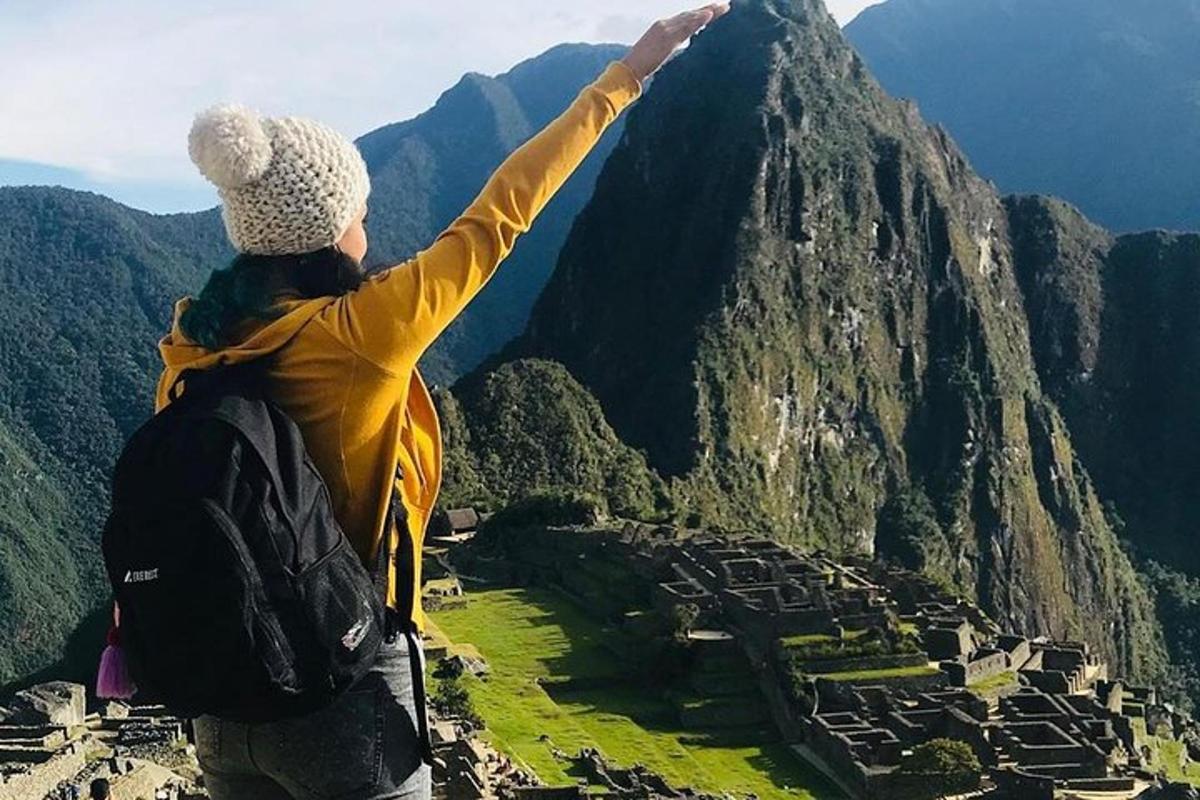 a woman standing on top of a mountain with her arm up