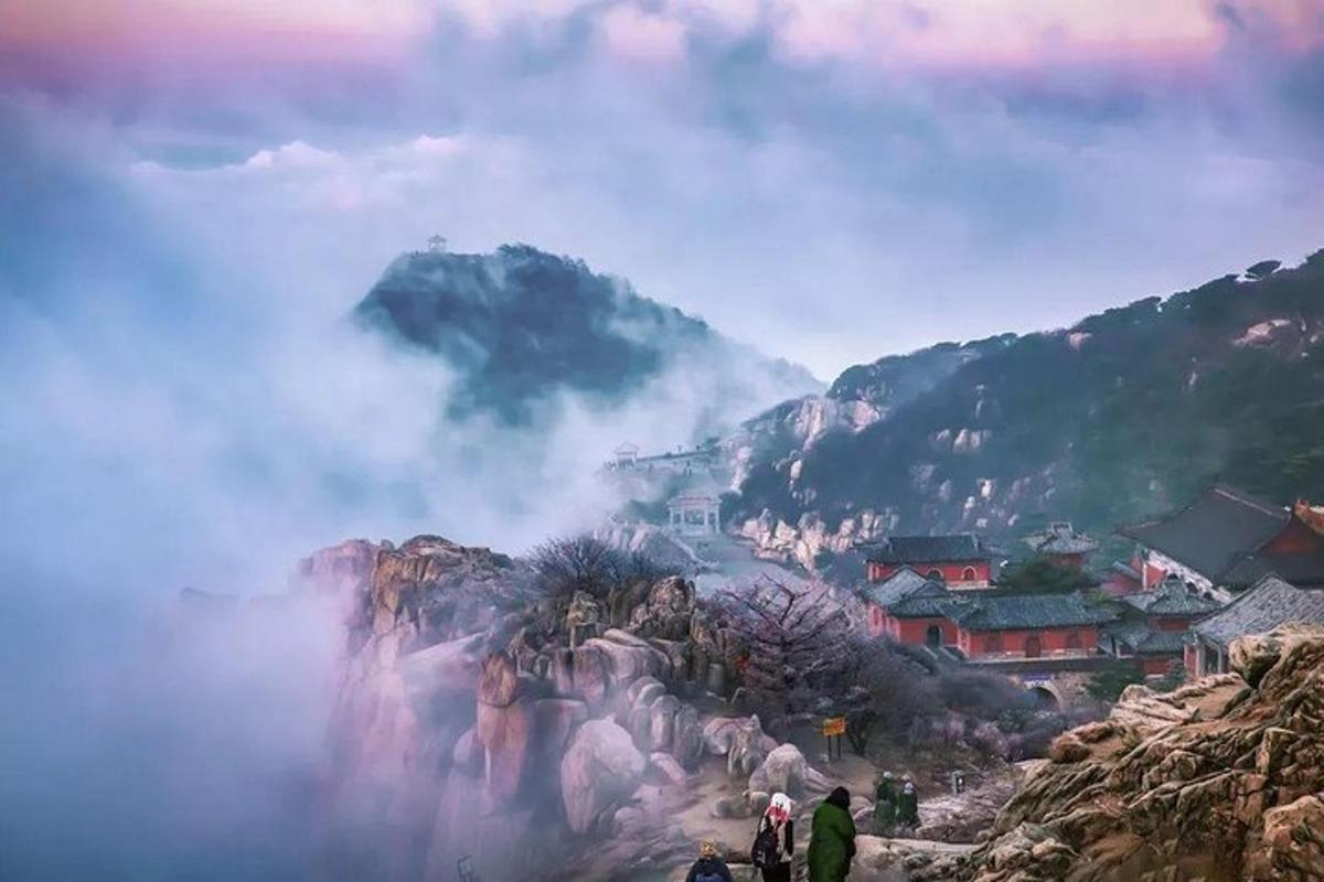 a group of people standing on a mountain in the clouds