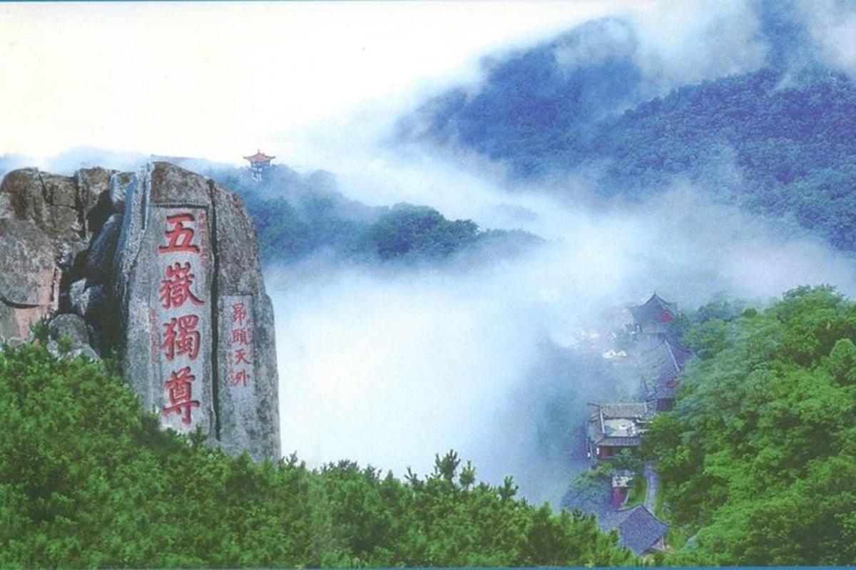 a misty mountain with a sign on top of it