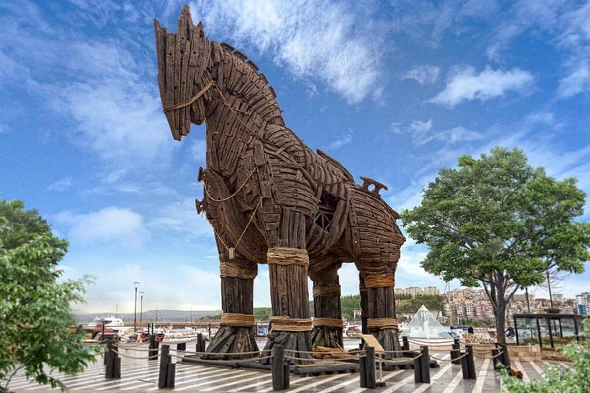 een groot houten paardenbeeld in een park