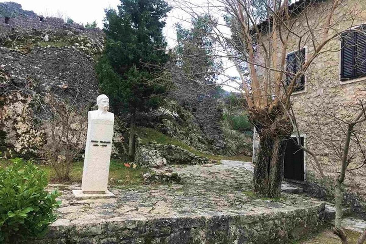 ένα άγαλμα σε έναν κήπο δίπλα σε ένα κτίριο
