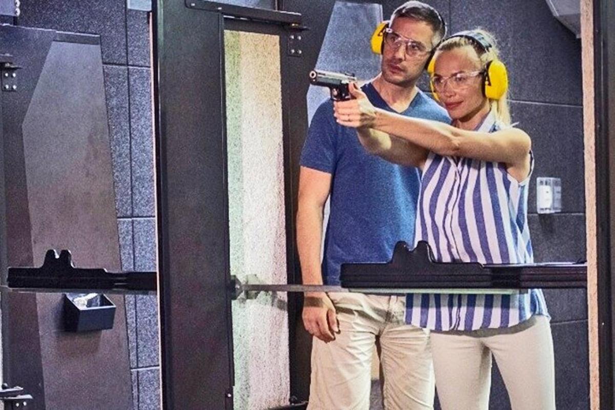 ein Mann und eine Frau mit Kopfhörern und einer Pistole