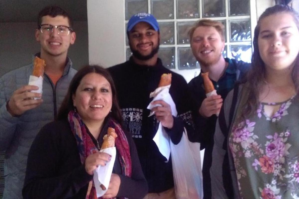 Un grupo de personas sosteniendo comida en sus manos.