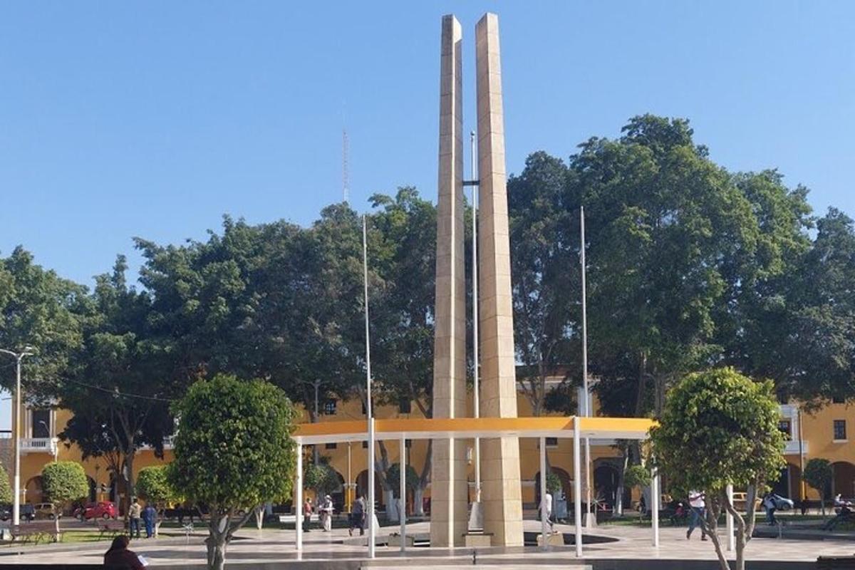 Un gran edificio con un monumento delante.
