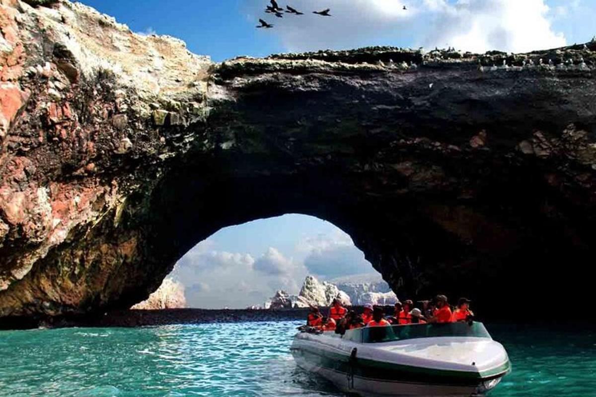 a group of people on a boat in front of a cave