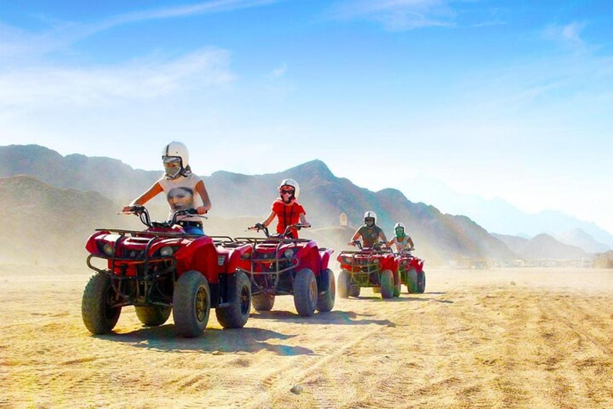 un gruppo di persone in sella a quad nel deserto