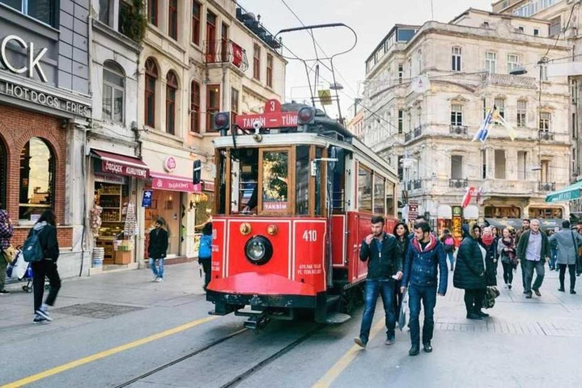 un tram rosso su una strada cittadina con persone