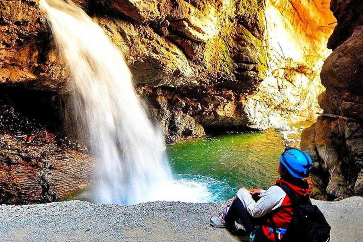 một người ngồi trên mặt đất bên cạnh một thác nước