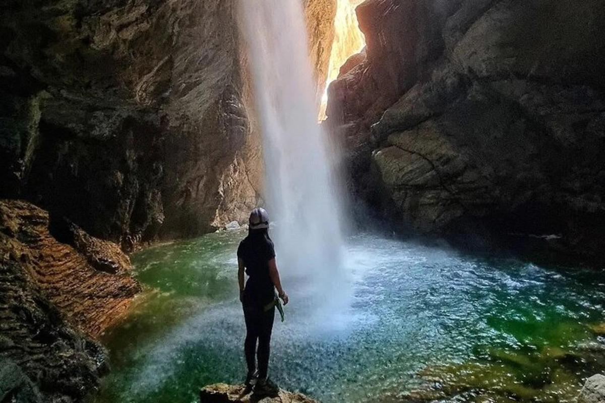 Ein Mann steht auf einem Felsen vor einem Wasserfall