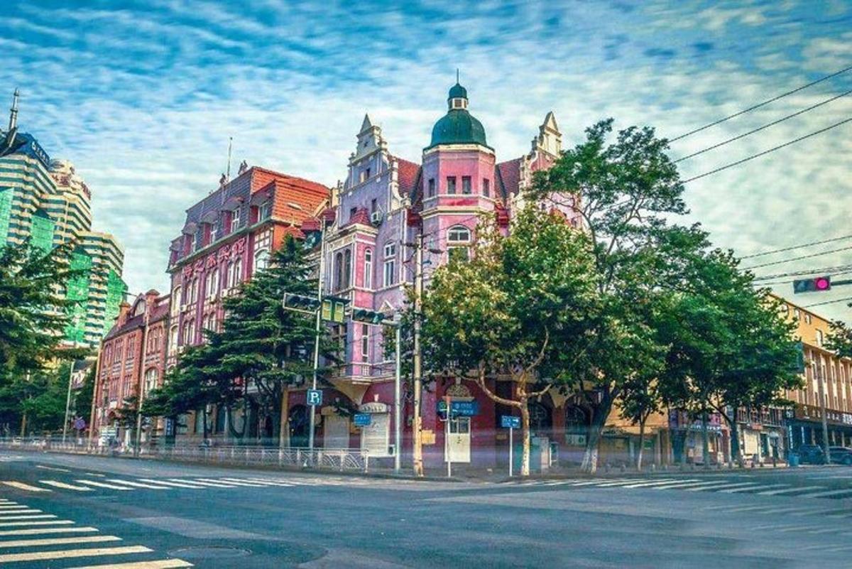 a large pink building on the side of a street