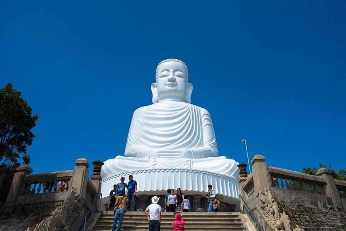 egy csoport ember áll egy nagy buddha-szobor körül