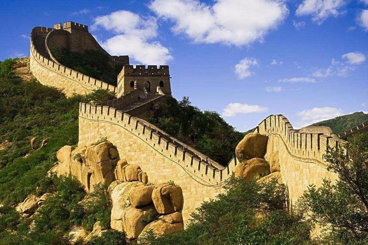 a stone wall with a castle on a hill