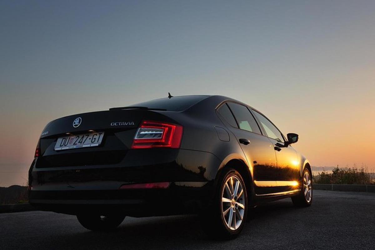 a black car is parked on a road
