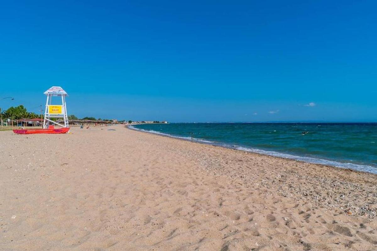 písečná pláž s věží plavčíků na oceánu